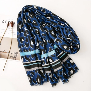 Detail of soft leopard print scarf with blue stripes and frayed fringe edges