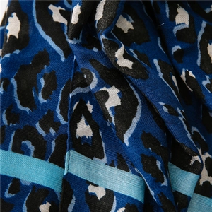 Close-up of blue leopard print scarf showing soft fabric texture and stripe detail