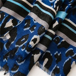 Detail of blue leopard print scarf showing soft cotton fabric texture and fringe edges