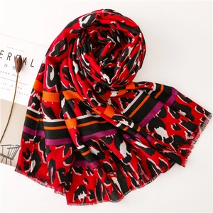 Detail of red leopard print scarf with striped accents and soft frayed edges