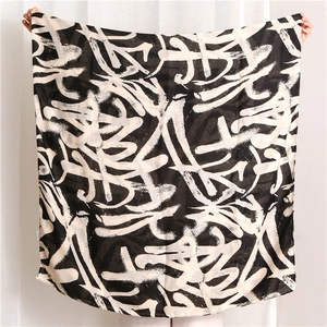 Detail of soft cotton scarf featuring black and white abstract graffiti printed patterns