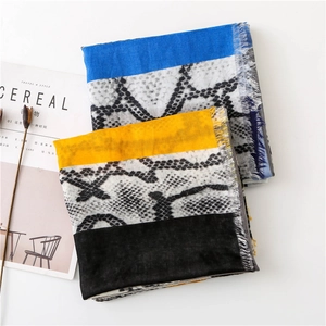 Detail of snake print scarves with contrast color blocks and frayed fringe edges