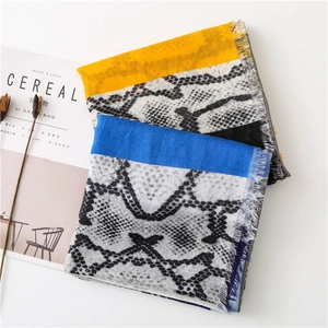 Close-up of leopard print scarves with contrast yellow and blue borders and fringe detail