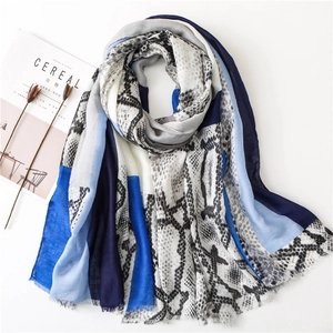 Detail of snake skin pattern shawl with frayed edges and blue color blocking