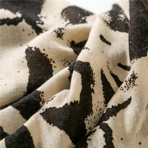 Detailed macro view of cotton linen scarf texture featuring black graffiti art print