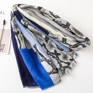 Detail of snake skin print scarf featuring color-block panels and soft fringe edges