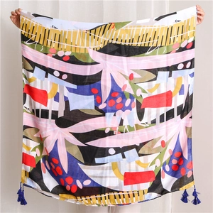 Detail of abstract tropical leaf print scarf with elegant navy blue corner tassels