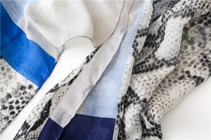 Detail of thin cotton linen scarf with blue color blocking and grey snakeskin print