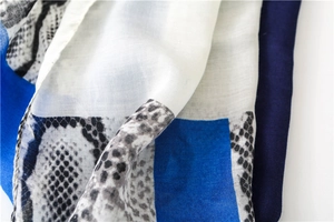 Detailed macro view showing the fine woven texture and snakeskin print of the cotton shawl