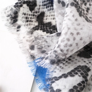 Macro view of animal print scarf with grey leopard pattern and blue fringe detail