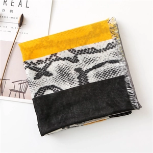 Detail of snake print scarf with yellow color blocking and delicate fringed edges