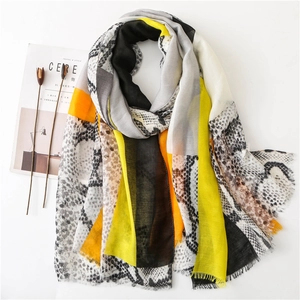 Detail of snake skin print scarf with vibrant color blocks and frayed fringe edges