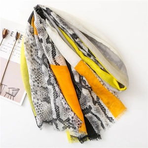 Detail of grey leopard print scarf with orange color blocks and frayed edge textures