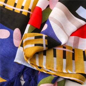 Detail of colorful geometric scarf with vibrant patterns and deep blue tassels