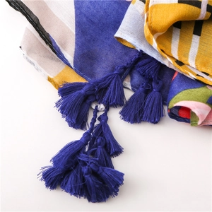 Close-up of geometric pattern scarf with deep blue tassels and linen texture