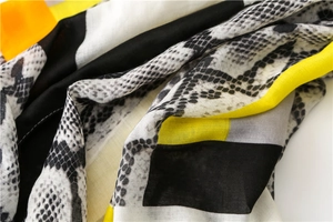 Detail of snake print scarf with geometric yellow blocks and light woven fabric