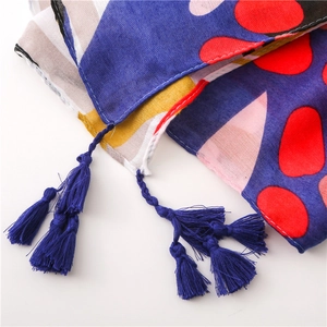 Detail of colorful geometric print scarf with dark blue tassels and cotton-linen texture