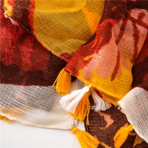 Detail of yellow and brown butterfly print scarf with two-tone tassel edge texture