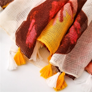 Detailed view of butterfly print scarf featuring ethnic color blocks and yellow tassels