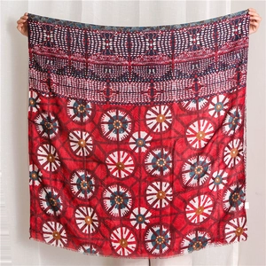Detail of red and navy cotton scarf with floral patterns, gold foil and fringe edges