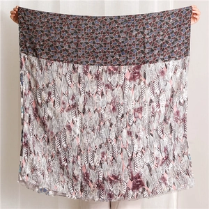 Detail of elegant cotton scarf featuring golden feather prints and mosaic patterns