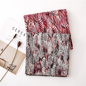 Detail of bohemian leaf print scarf with feather patterns and soft frayed edges