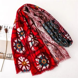 Detail of red floral cotton linen scarf with elegant gold foil feathers and tassels