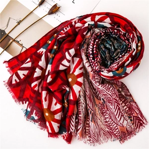 Detail of red floral scarf with gold foil feathers and delicate frayed edges