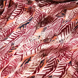 Detailed macro view of soft cotton-blend scarf with orange and red leaf patterns