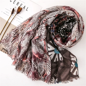 Detail of cotton linen scarf with golden feather prints and soft frayed edges