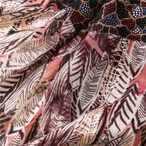 Detail of elegant gold foil feather embroidery and intricate patterns on cotton linen shawl