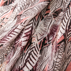 Close-up of lightweight cotton scarf with gold feather embroidery and floral patterns