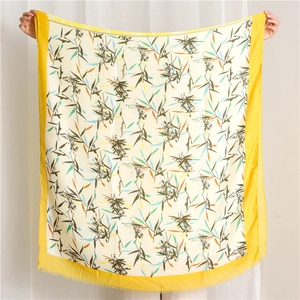 Détail d'une écharpe à motif de feuilles de bambou avec bords jaunes et franges
