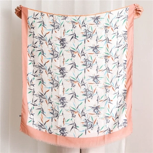 Détail d'un châle en lin avec bord rose et motif imprimé de feuilles de bambou