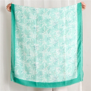 Détail d'une écharpe vert menthe avec imprimé feuilles de bambou et bords effilochés