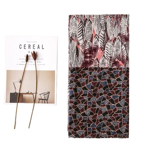 Elegant cotton linen scarf with red leaf pattern and stone print in flat lay view
