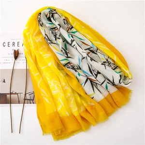Détail d'une écharpe en coton jaune avec imprimé bambou et bords à franges en vue à plat