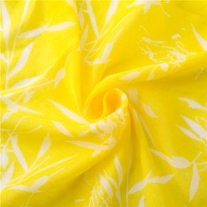 Texture détaillée d'une écharpe légère en coton et lin jaune aux motifs floraux blancs