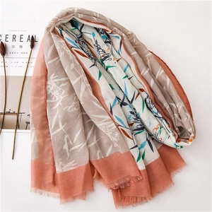 Détail d'une écharpe en coton et lin à fleurs avec feuilles de bambou et franges