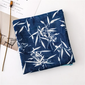 Détail de l'écharpe bleu foncé avec motifs de feuilles de bambou blancs en coton et lin