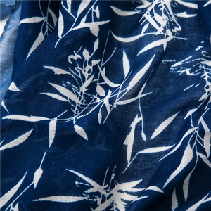Gros plan d'une écharpe en coton et lin avec des motifs de feuilles bleues et blanches