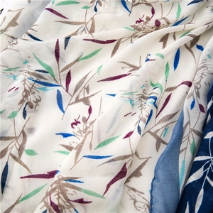 Gros plan d'une écharpe en coton et lin avec des motifs de feuilles de bambou bleues