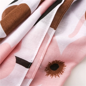 Macro detail of floral print cotton linen scarf showing pink petals and fine stitching