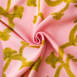 Gros plan d'une écharpe rose avec motifs floraux rétro et texture soyeuse douce