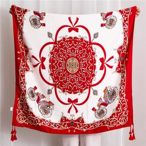 Detail of printed silk shawl featuring red carriage motifs and elegant fringe tassels