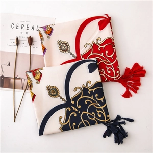 Close-up of baroque print satin scarves with tassels and floral decorative elements