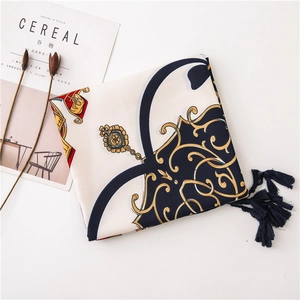 Detail of printed scarf with vintage baroque chain patterns and navy tassels