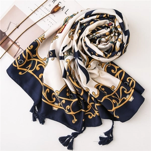 Macro view of baroque scroll patterns and dark blue tassels on a silk-touch scarf