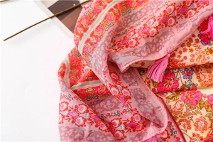 Detail of pink floral ethnic shawl with bohemian prints and handmade fringe tassels