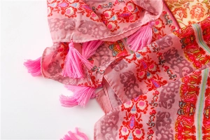 Detail of pink bohemian floral print on cotton linen scarf with bright pink tassels